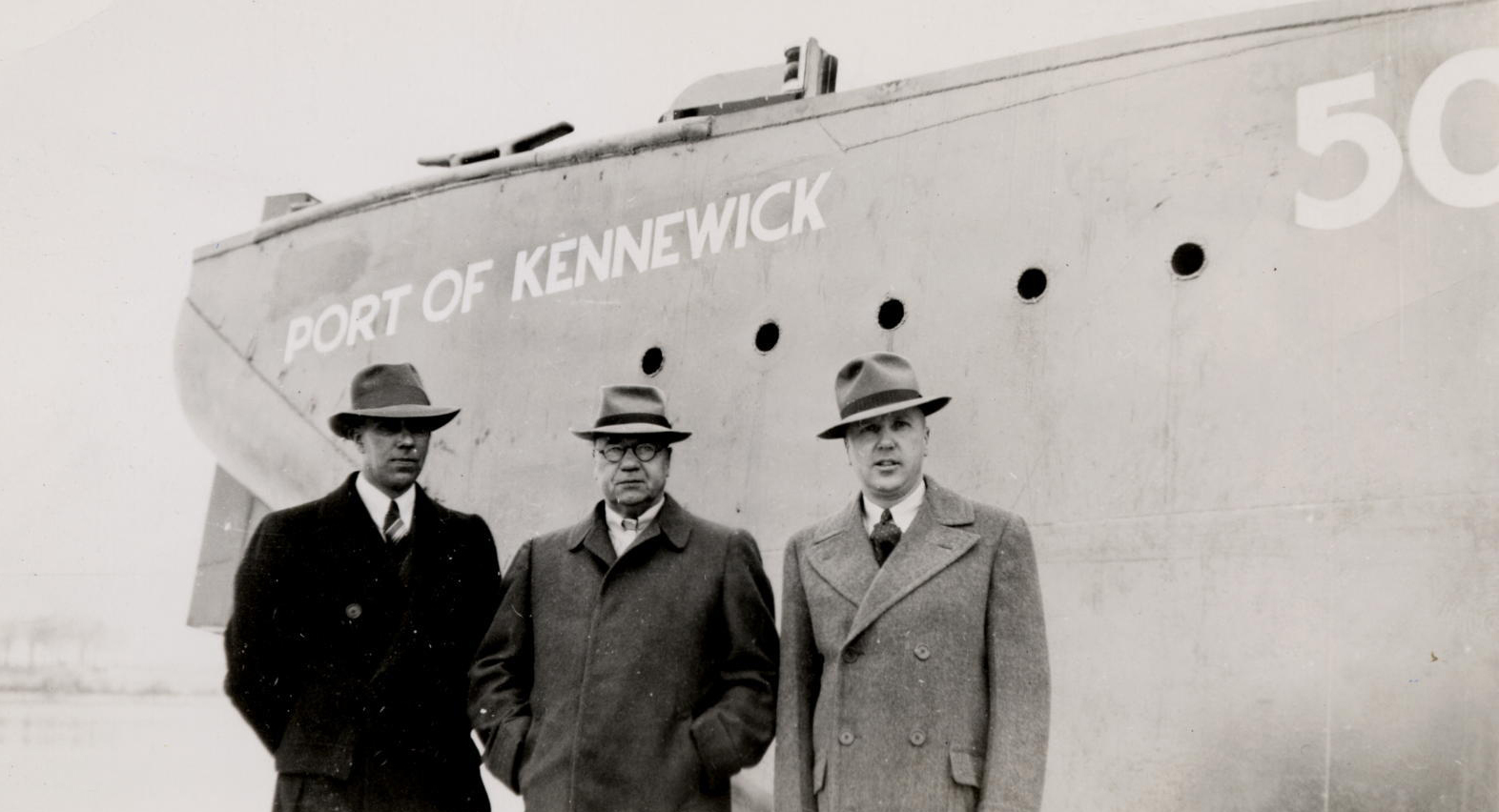 Port Commissioners, A. I. Smith, George R. Turner and Harry A. Linn attend an early 1940s barge launch.