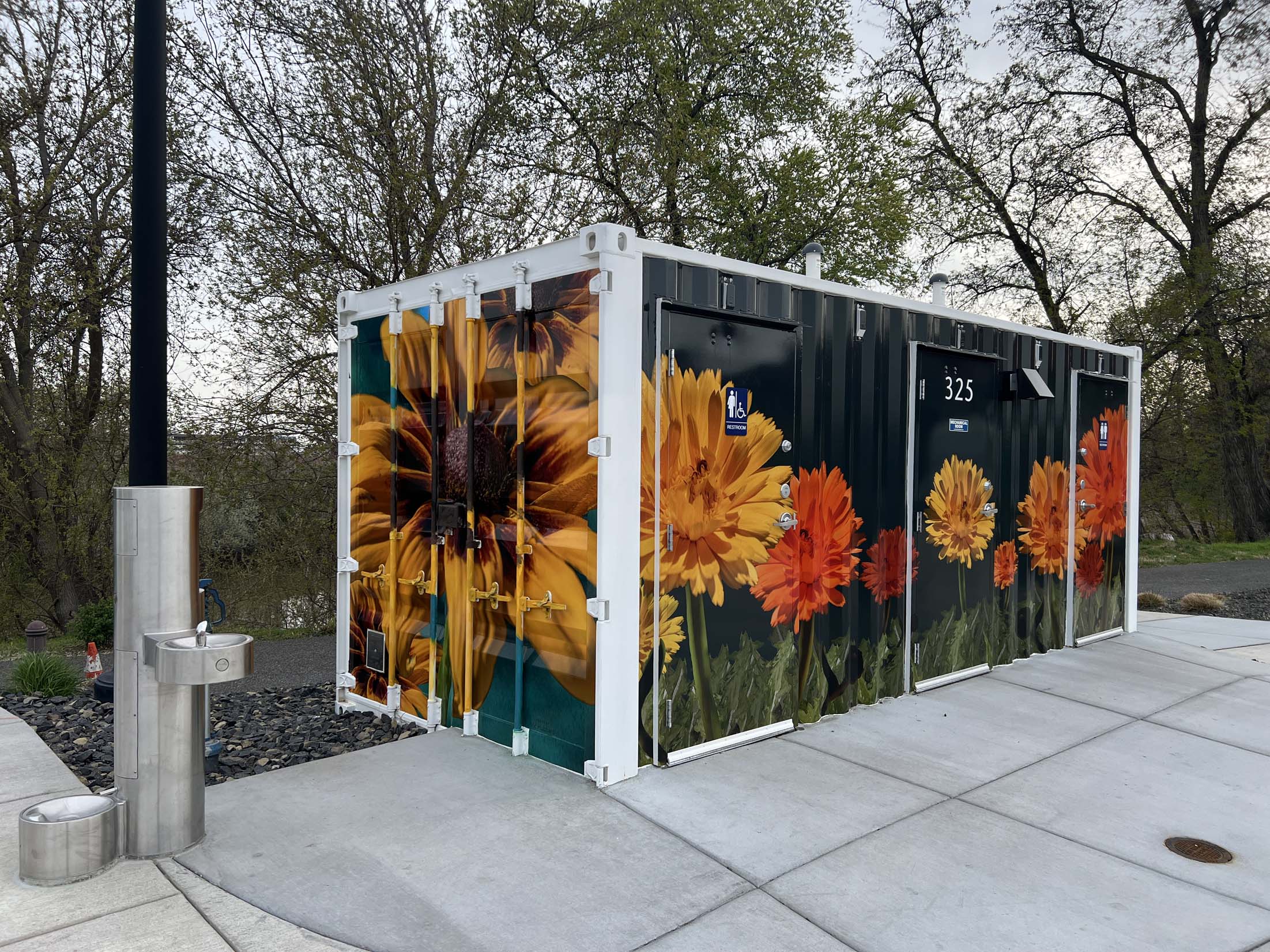 Stylized images of Heliopsis False Sunflowers and Black-Eyed Susans span the front and one end of a shipping container art wrap at Columbia Gardens.