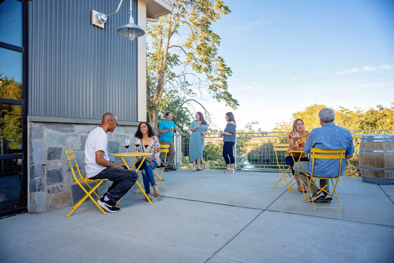 Guests enjoying food and drinks on a tasting room's outdoor patio.