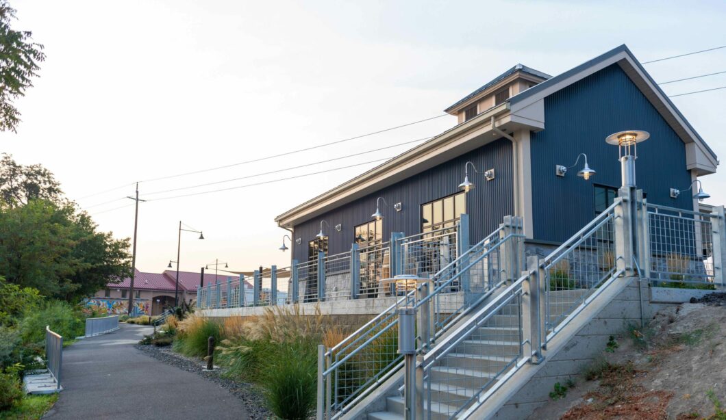 Exterior of a tasting room building at Columbia Gardens overlooking the pathway and interior waterfront.